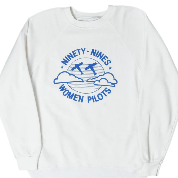 Front of white Ninety-Nines women pilots sweatshirt with blue airplane and cloud graphic.