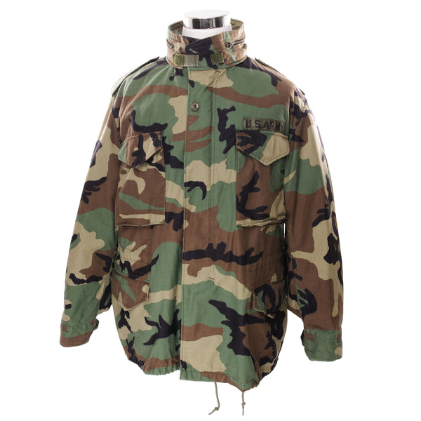 Vintage US Army M-1965 M65 Woodland Camouflage Pattern Patched Field Jacket 1996 Size XLarge Regular  STOCK NO. 8415-01-099-7841  SP0100-96-D-0320  The M-65 field jacket was widely used by United States forces during the Vietnam War and became a classic used by the U.S. troops in several other wars all around the world. 