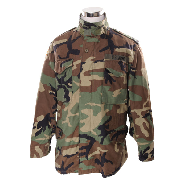 Vintage US Army M-1965 M65 Woodland Camouflage Pattern Field Jacket With Patch 1999 Size Medium Regular  STOCK NO. 8415-01-099-7835  SP0100-99-D-0303  The M-65 field jacket was widely used by United States forces during the Vietnam War and became a classic used by the U.S. troops in several other wars all around the world. 