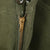 Close-up of the brass zipper fly and olive green fabric on US Army M51 wool field trousers.