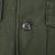 Close-up of four-hole front button and olive green sateen fabric on US Army utility shirt