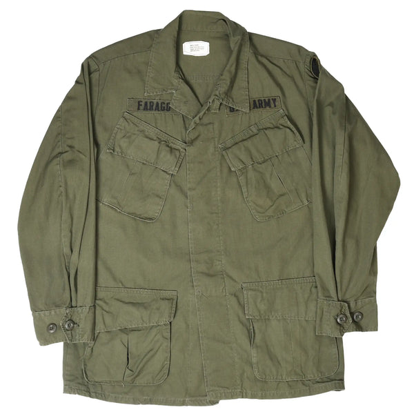 Full front of olive US Army tropical combat jacket with four flap pockets and patches