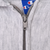 Close-up of metal YKK zipper pull and Champion label on gray full-zip hoodie