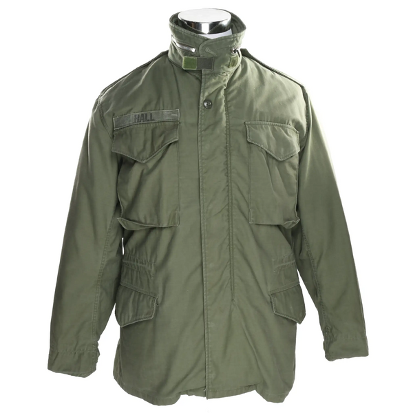 Front of olive green US Army M65 field jacket with four flap pockets and Hall name tape