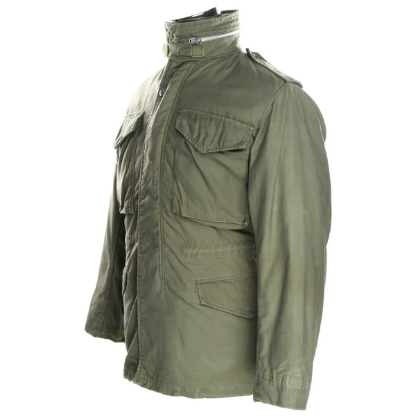 Three-quarter side view of olive green US Army M65 field jacket with flap pockets and shoulder epaulet