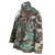 Three-quarter front view of US Army M65 Woodland camo field jacket with four flap pockets