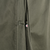 Close-up of the overcoat belt loop area with a small marked opening in the seam