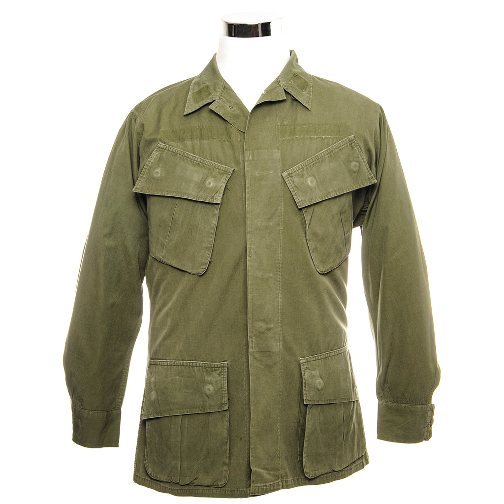 The 3rd major version of the Tropical Combat Coat was first produced in 1966 and had no gas flap, epaulets, waist tabs or pocket drain holes. It was the first jungle jacket to have a back yoke and was made in both OG-107 and ERDL camouflage. Like all prior models it was made from wind-resistant cotton poplin and had pen pockets behind both chest cargo pockets.